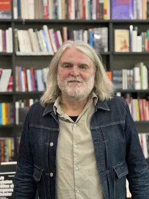 Portraitaufnahme Thomas Irmer vor einem Bücherregal