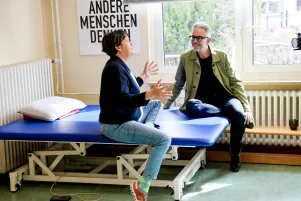 Birgit Deininger und Oliver Reese sind lebhaft im Gespräch. Im Hintergrund steht auf einem Plakat: "Andere Menschen denken."