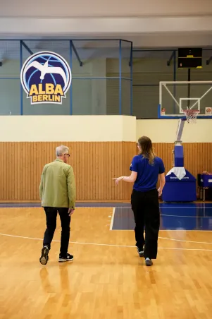 Oliver Reese und Wiebke Schwartau von hinten in Bewegung, sie gehen auf den Basketballkorb zu