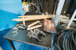 Auf einem schwarzen Holztisch liegen verschiedene Requisiten, darunter ein großer Schlüsselbund, hölzerne Schwerter und weitere Gegenstände aus ähnlichem Material.  