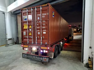 Ein rostroter LKW fährt rückwärts an die Ladefläche.