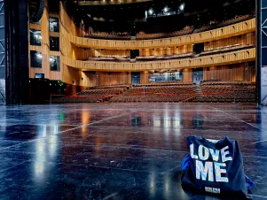 Blick von der Bühne in den Zuschauerraum. Rechts unten im Bild ist ein BE-Beutel mit der Aufschrift "Love me" zu erkennen. 