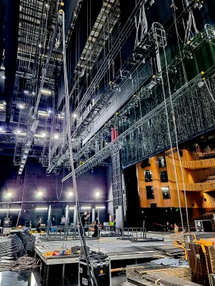 Aufbau des Bühnenbildes, Blick vom Bühnenboden hoch in den Schnürboden, es ist der Glitzervorhang zu erkennen. 