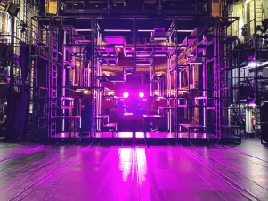 Das Bühnenbild der "Dreigroschenoper" wird pink beleuchtet. 