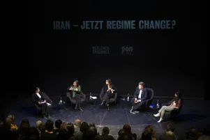 Blick auf das diskutierende Panel: Die Gesprächspartner:innen unterhalten sich. 