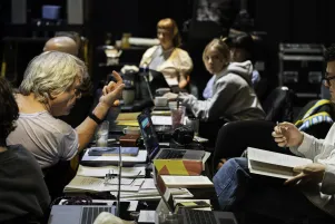 Schnappschuss vom Regietisch: Johan lehnt sich links im Bild zum Tisch, um ihn herum sind die Produktionsbeteiligten bei der Arbeit zu erkennen. 