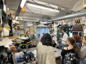 Die Teilnehmer:innen schauen sich interessiert in den vollen Werkstätten der Requisite um. 