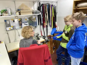 Zwei Kinder unterhalten sich mit einer Kollegin aus der Maske. 