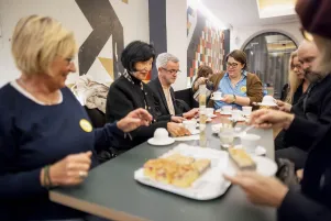 Schnappschuss aus der Kantine: Einige Freund:innen essen gemeinsam Kuchen, lachen und unterhalten sich. 