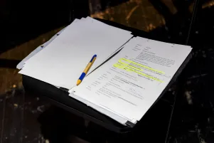 Schnappschuss eines Textbuchs: Es sind gelbe Markierungen, Stifte und lose Seiten zu erkennen. 