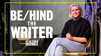 Regisseurin Fritzi Wartenberg in der Kulisse von "The Writer" sitzend in die Kamera lächelnd