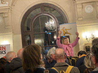 Im Foyer des Großen Hauses hält eine Frau eine der Livezeichnungen hoch, vor ihr sind viele Menschen zu erkennen. 
