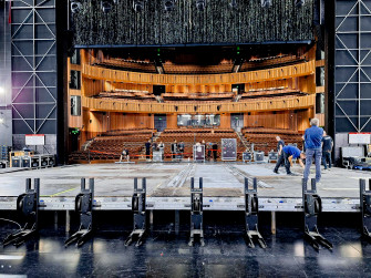 Blick vom Bühnenhorizont auf den Publikumssaal, einige Techniker arbeiten in der Bühnenmitte. 