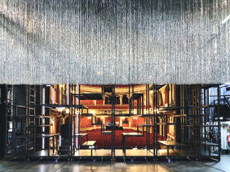 Rückansicht des Bühnenbildes von der "Dreigroschenoper". Der glitzernde Vorhang ist genau zur Bildmitte herabgelassen. 