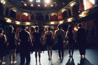 Blick von der BE-Bühne in den Zuschauerraum. An der Rampe stehen acht Tänzer:innen, denen applaudiert wird. 