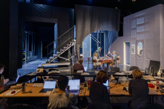 Blick auf den Regietisch und die gefüllte Probebühne samt Bühnenbild. 