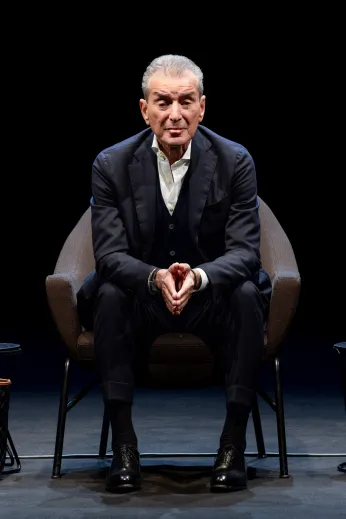 Michel Friedman auf einem Stuhl nach vorn gelehnt