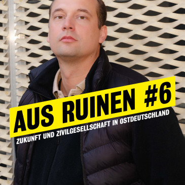 Portrait von Hendrik Bolz im Halbprofil vor dem neuen Haus. Darauf steht "Aus Ruinen #6. Zukunft und Zivilgesellschaft in Ostdeutschland."