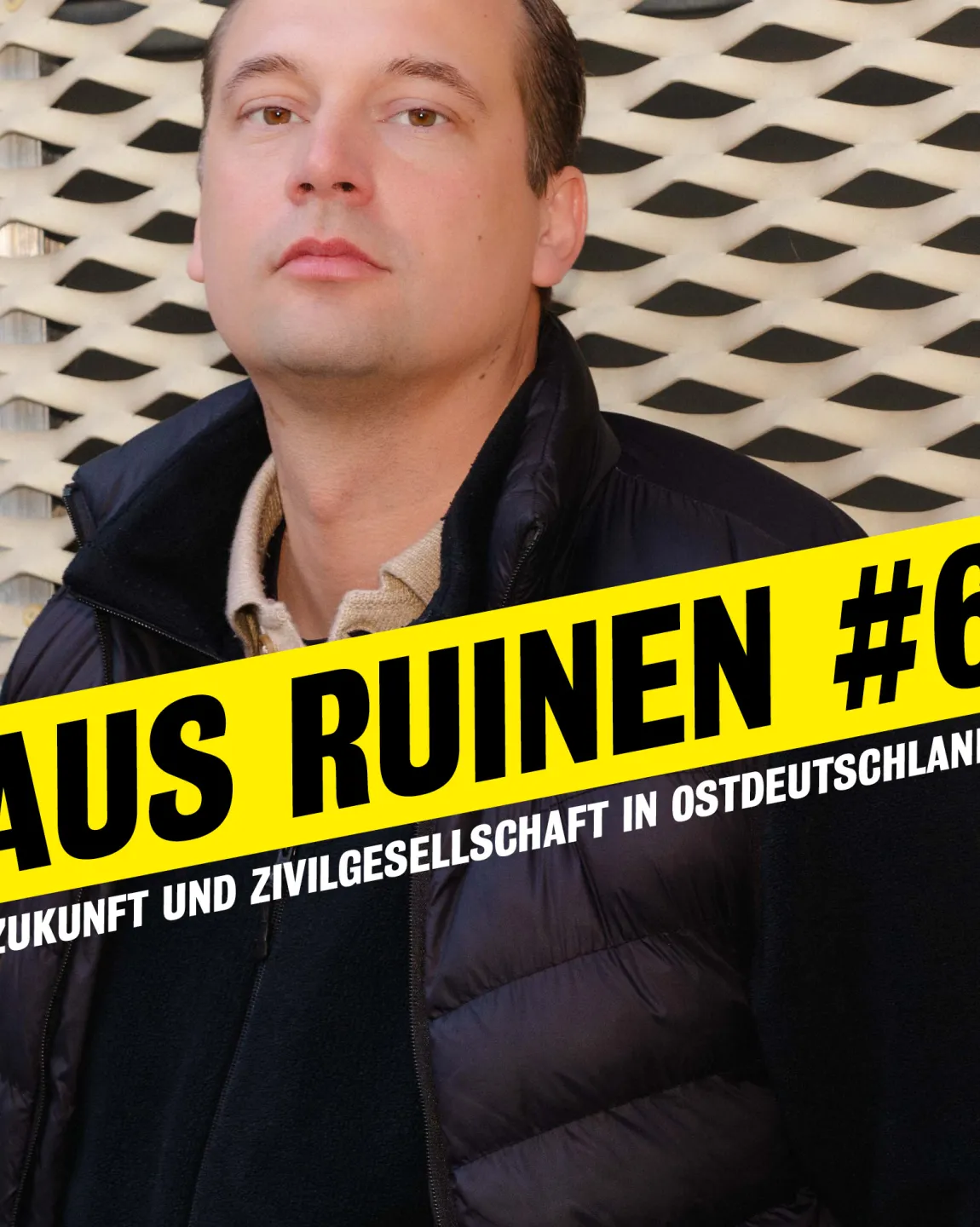Portrait von Hendrik Bolz im Halbprofil vor dem neuen Haus. Darauf steht "Aus Ruinen #6. Zukunft und Zivilgesellschaft in Ostdeutschland."