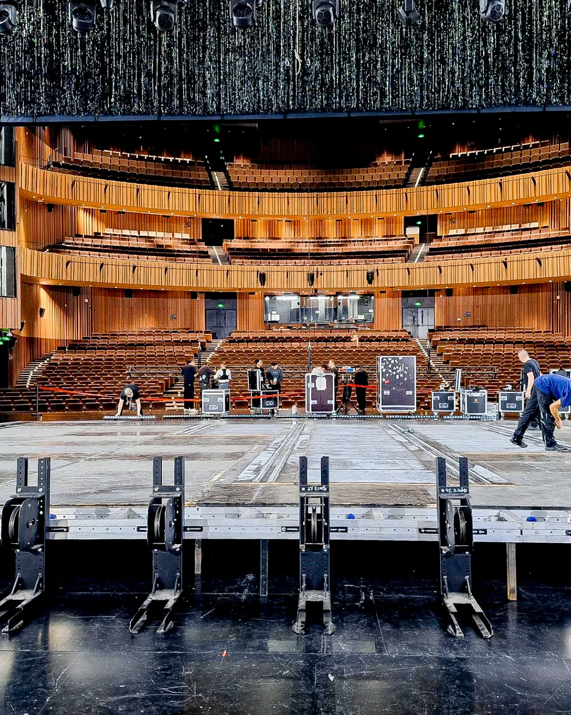 Blick vom Bühnenhorizont auf den Publikumssaal, einige Techniker arbeiten in der Bühnenmitte. 