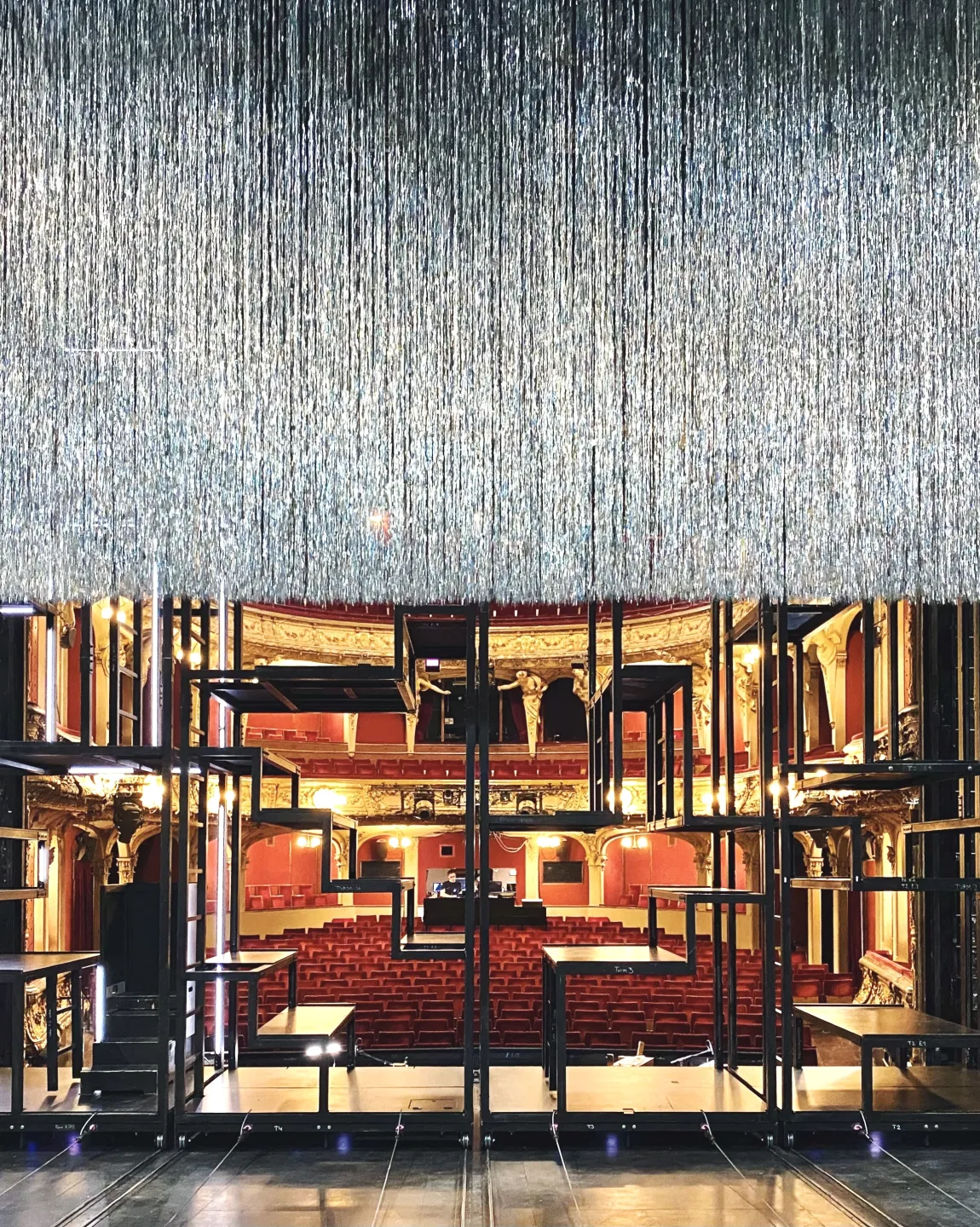 Rückansicht des Bühnenbildes von der "Dreigroschenoper". Der glitzernde Vorhang ist genau zur Bildmitte herabgelassen. 