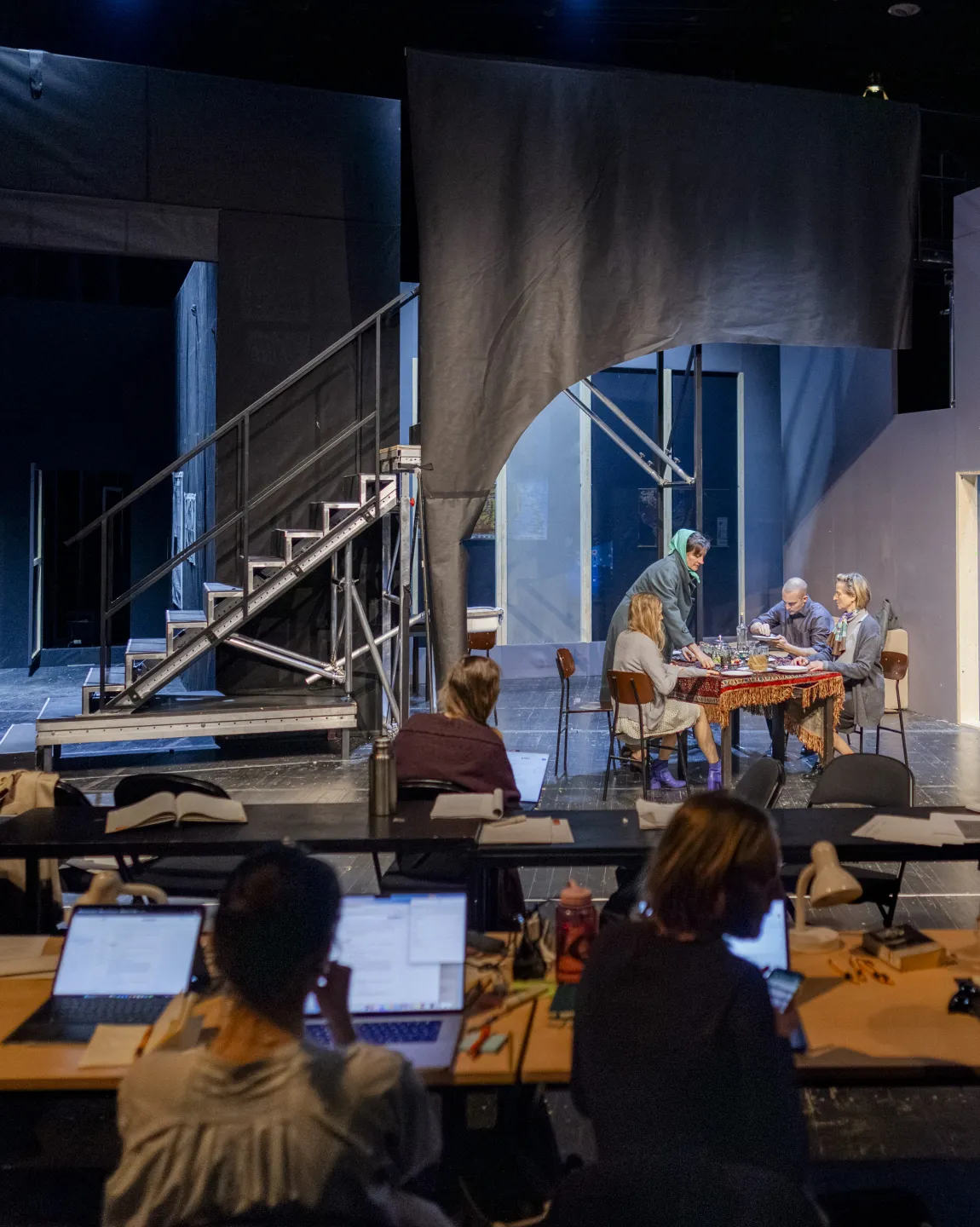 Blick auf den Regietisch und die gefüllte Probebühne samt Bühnenbild. 