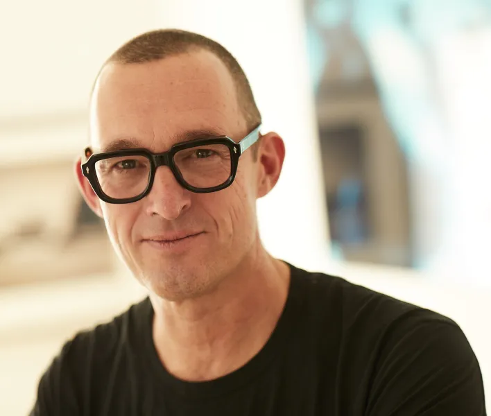 Albert Ostermaier mit Brille und schwarzem T-Shirt, der Hintergrund ist unscharf.